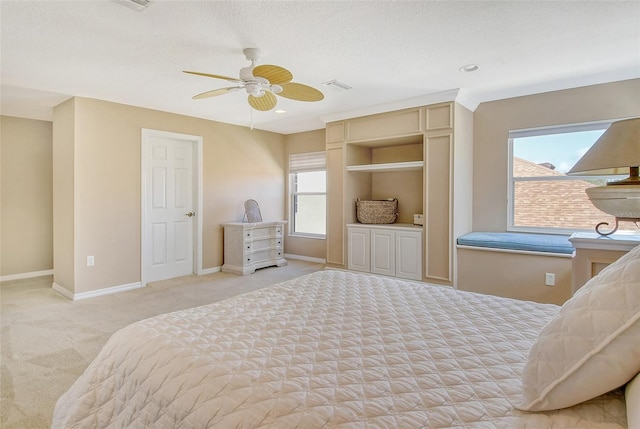 bedroom featuring ceiling fan, light carpet, and a textured ceiling