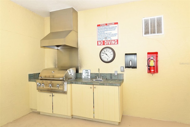 kitchen featuring wall chimney range hood and sink