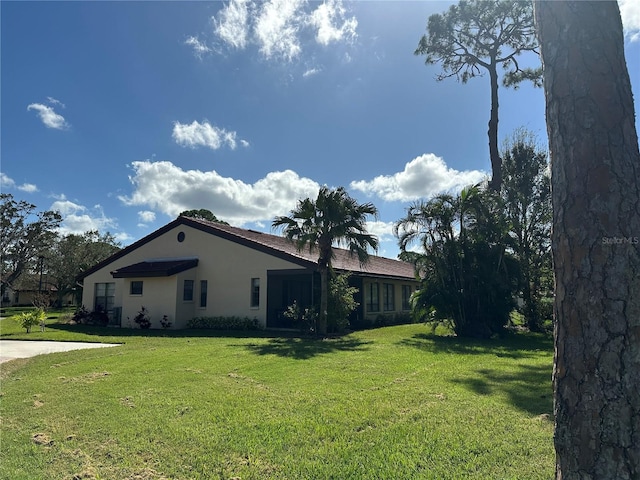 view of side of home with a yard