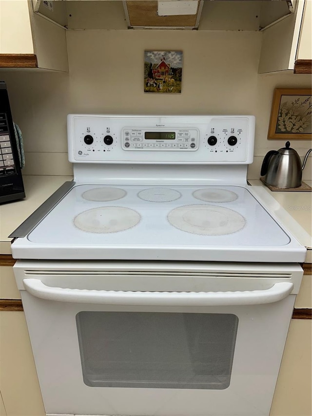 details with white electric range oven and white cabinets