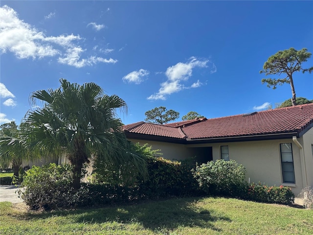 view of side of home with a yard