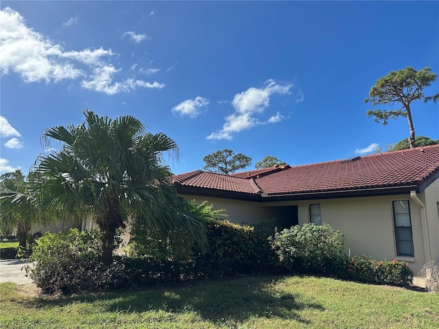 3711 Pinecone Ct Unit 168, Sarasota, FL 34238 - view of side of property featuring stucco siding, a lawn, and a tiled roof