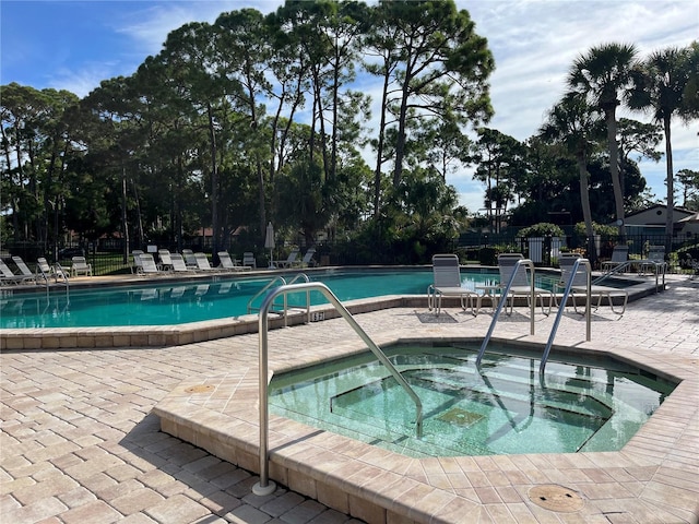 view of pool with a hot tub and a patio area