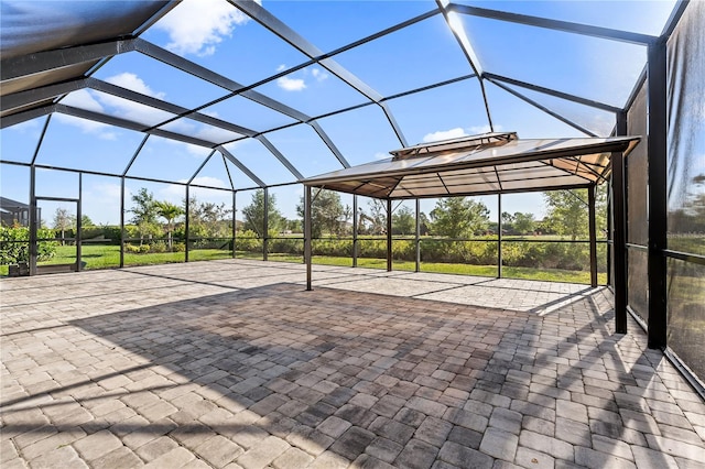 view of patio featuring glass enclosure