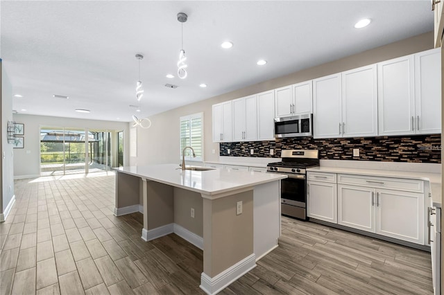 kitchen with plenty of natural light, appliances with stainless steel finishes, sink, and hanging light fixtures