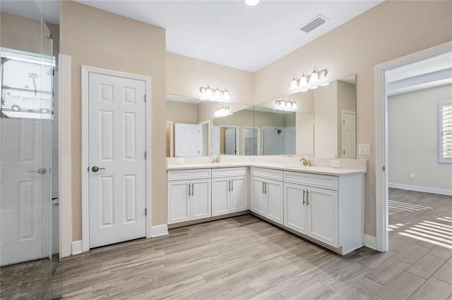 bathroom featuring hardwood / wood-style flooring, vanity, and walk in shower