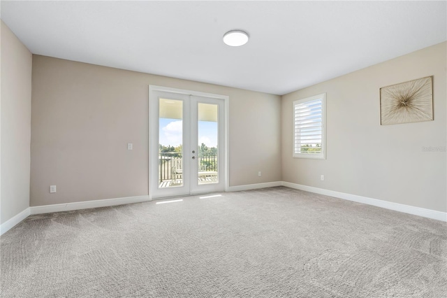 spare room with a wealth of natural light, carpet flooring, and french doors