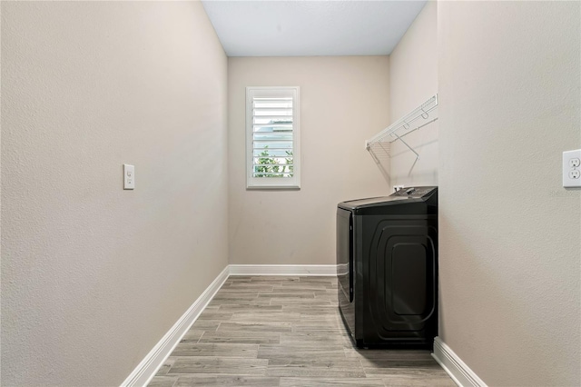 clothes washing area featuring light wood-type flooring