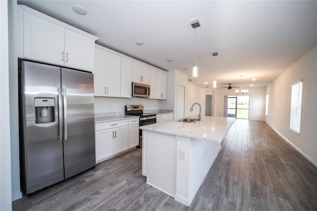 kitchen featuring wood-type flooring, a center island with sink, sink, white cabinetry, and appliances with stainless steel finishes