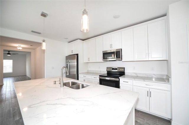 kitchen featuring a center island with sink, sink, pendant lighting, and appliances with stainless steel finishes