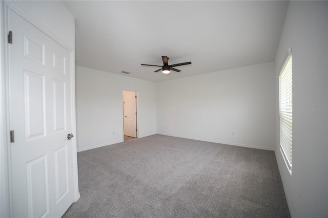 carpeted spare room featuring ceiling fan