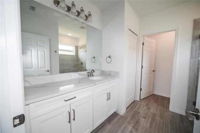 bathroom featuring walk in shower, wood-type flooring, and vanity