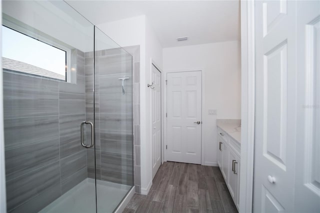 bathroom featuring a shower with door, wood-type flooring, and vanity