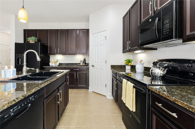 kitchen featuring sink, black appliances, dark stone counters, light tile patterned floors, and decorative light fixtures