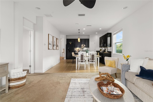 carpeted living room with ceiling fan