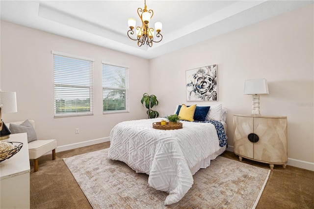 carpeted bedroom with a raised ceiling and an inviting chandelier