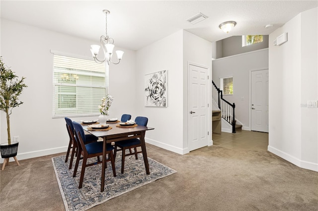 carpeted dining area featuring an inviting chandelier