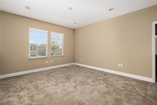 carpeted empty room featuring a textured ceiling