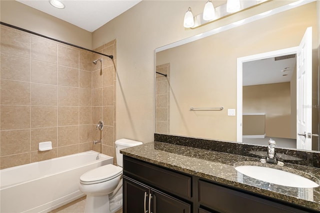 full bathroom featuring toilet, vanity, and tiled shower / bath