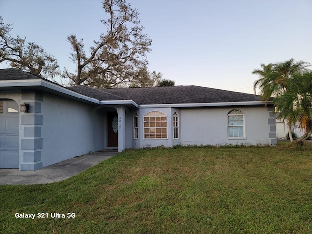 view of front of property featuring a garage and a yard