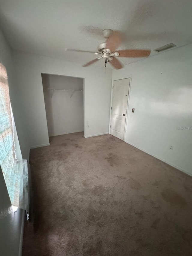 unfurnished bedroom with ceiling fan, a closet, and carpet floors