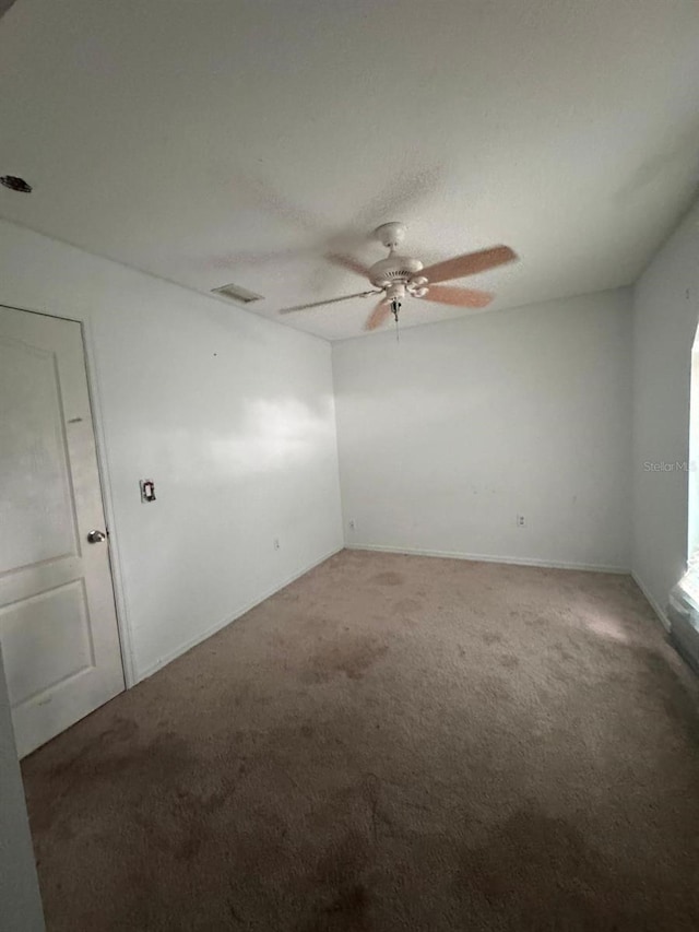 empty room featuring ceiling fan and carpet flooring