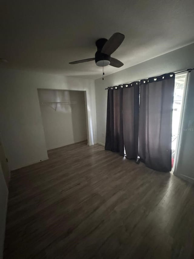 empty room featuring dark hardwood / wood-style flooring and ceiling fan