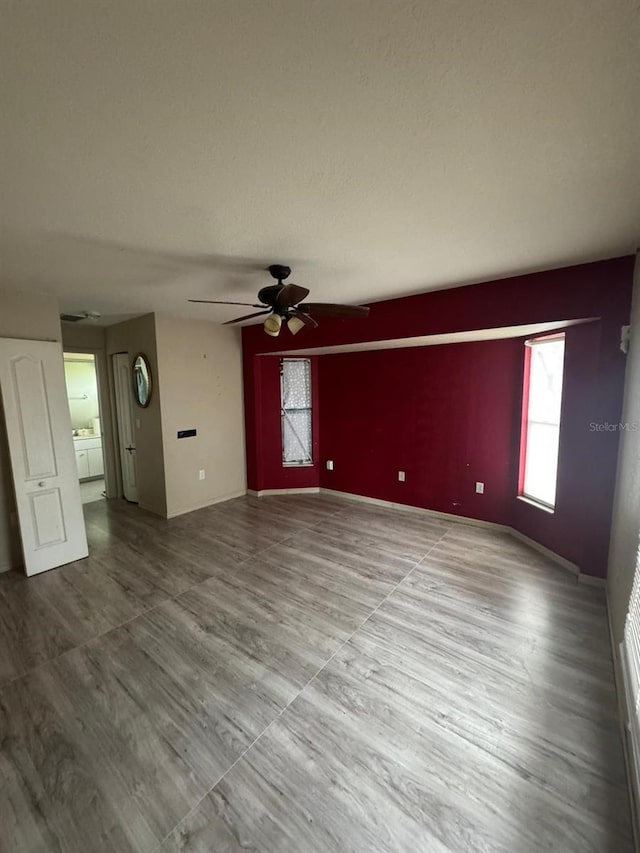 unfurnished living room with hardwood / wood-style floors and ceiling fan