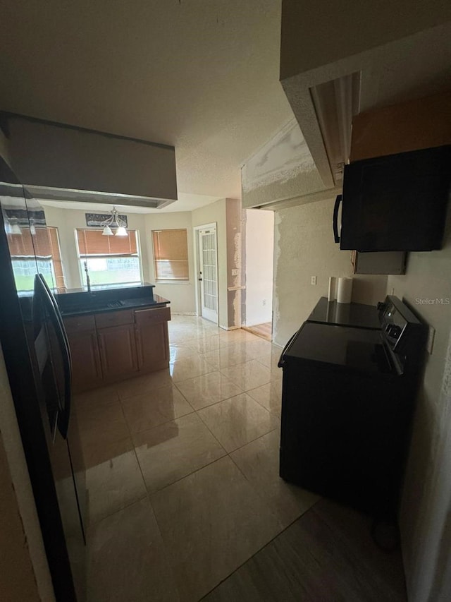 kitchen featuring refrigerator, ceiling fan, light tile patterned floors, and black stove