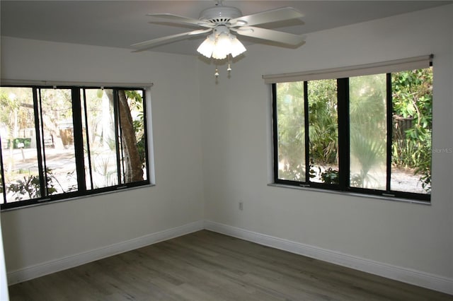 unfurnished room with ceiling fan, a healthy amount of sunlight, and dark hardwood / wood-style flooring