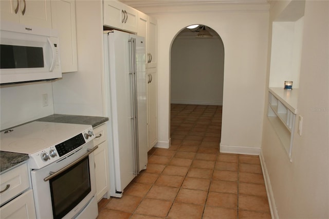 kitchen featuring light tile patterned flooring, crown molding, white cabinets, and white appliances