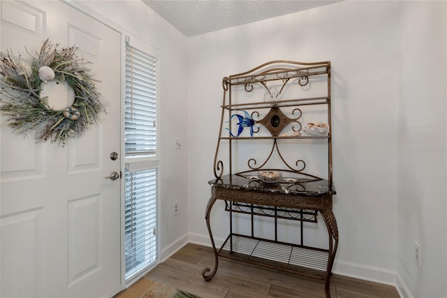 foyer entrance with hardwood / wood-style floors and a textured ceiling