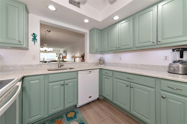 kitchen featuring dishwasher, sink, stainless steel range, light hardwood / wood-style flooring, and decorative light fixtures