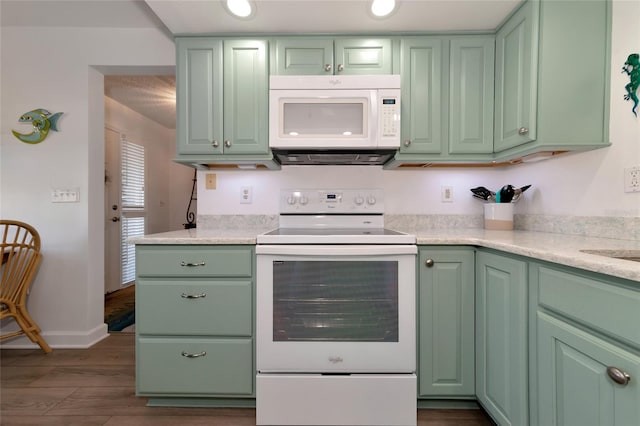 kitchen featuring white appliances, green cabinetry, and dark hardwood / wood-style flooring