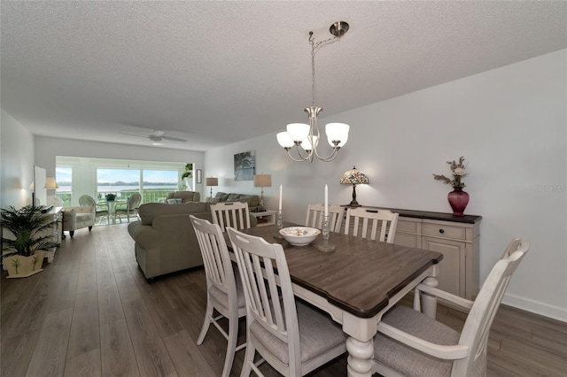 dining space featuring a textured ceiling, dark hardwood / wood-style floors, and ceiling fan with notable chandelier