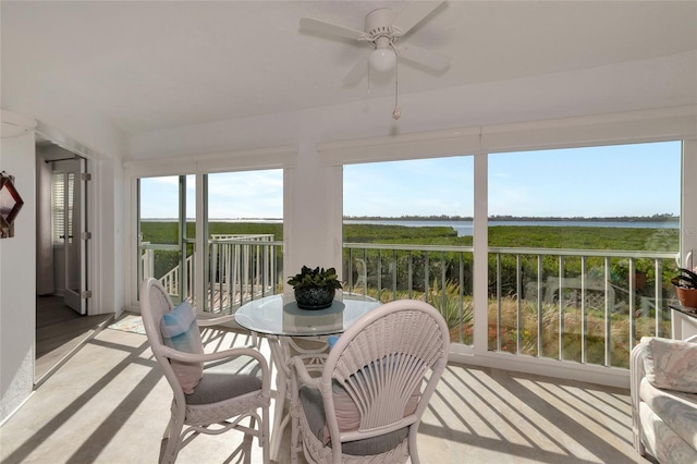 sunroom with a water view and ceiling fan