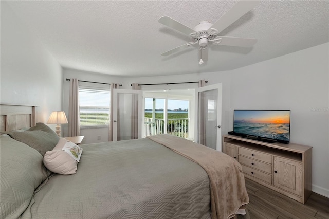 bedroom featuring a textured ceiling, access to outside, dark hardwood / wood-style flooring, and ceiling fan