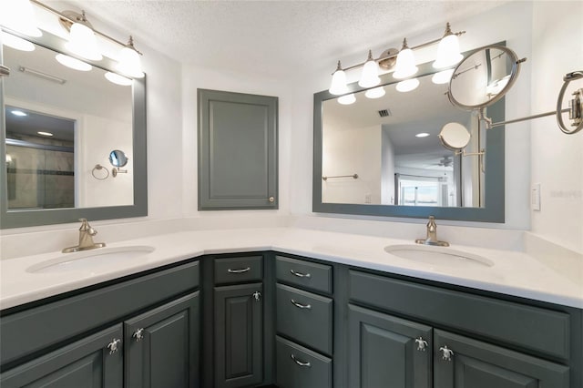 bathroom featuring vanity, walk in shower, and a textured ceiling