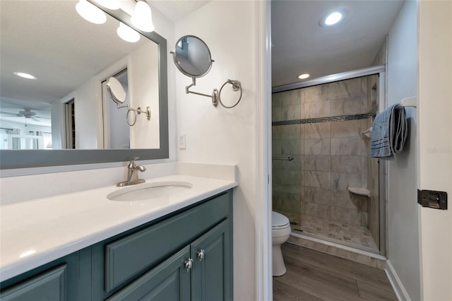 bathroom with toilet, vanity, an enclosed shower, and wood-type flooring