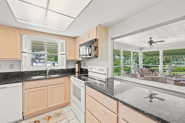 kitchen featuring a healthy amount of sunlight, light brown cabinets, sink, and white appliances