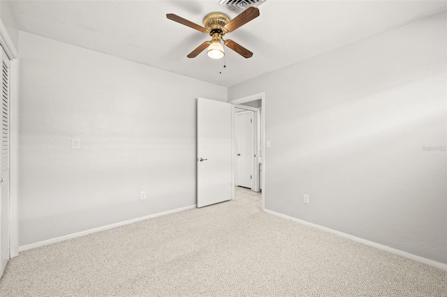 unfurnished bedroom featuring ceiling fan, a closet, and light colored carpet