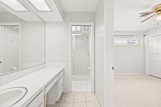 bathroom with ceiling fan, a shower with shower door, vanity, and tile patterned flooring