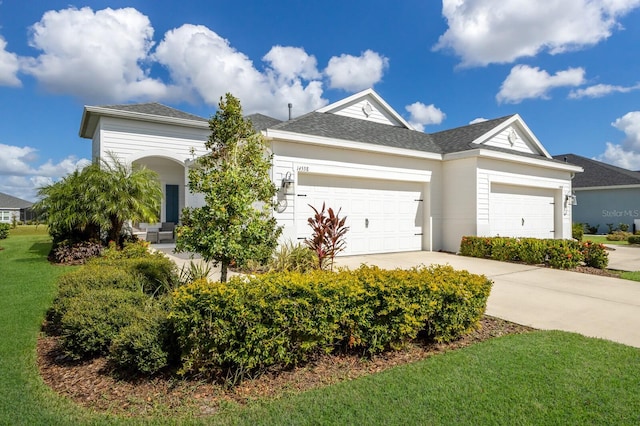 14538 Barefoot Ln, Parrish, FL 34219 - ranch-style home with a garage, concrete driveway, a front lawn, stucco siding, and roof with shingles