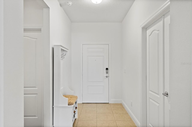 corridor with light tile patterned flooring and a textured ceiling