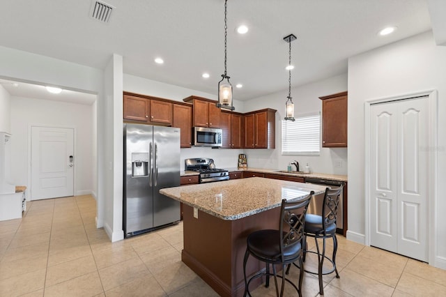 14538 Barefoot Ln, Parrish, FL 34219 - kitchen featuring appliances with stainless steel finishes, a sink, a center island, recessed lighting, and light stone counters