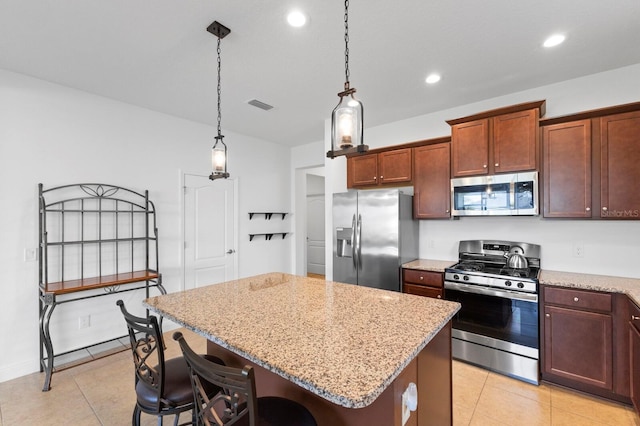14538 Barefoot Ln, Parrish, FL 34219 - kitchen with stainless steel appliances, light tile patterned floors, a kitchen island, light stone counters, and recessed lighting