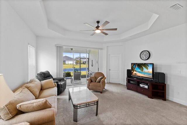 14538 Barefoot Ln, Parrish, FL 34219 - living area featuring a raised ceiling, ceiling fan, light colored carpet, and baseboards
