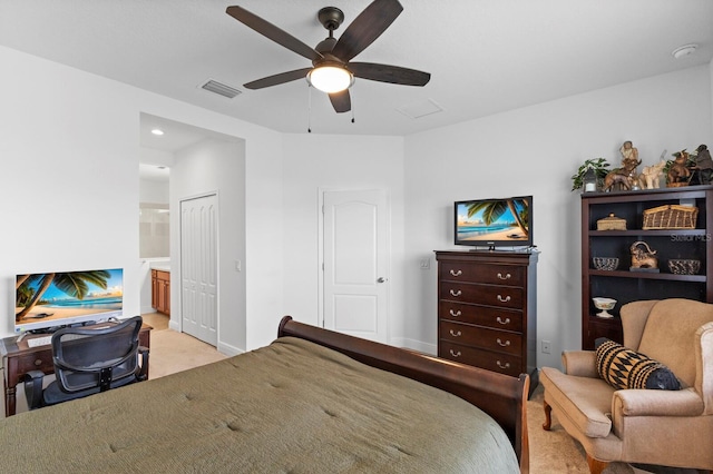 carpeted bedroom with a closet, ceiling fan, and ensuite bath