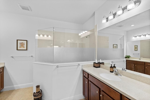 14538 Barefoot Ln, Parrish, FL 34219 - bathroom featuring two vanities, walk in shower, and tile patterned flooring