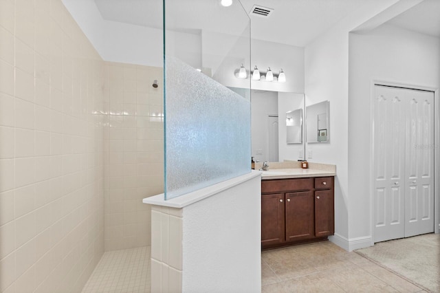 bathroom featuring vanity, tile patterned floors, and tiled shower